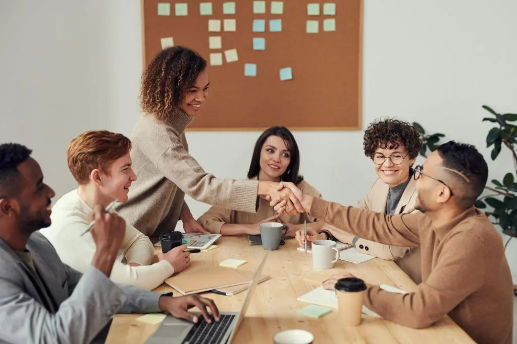 Work colleagues sit and engage in teamwork around office table
