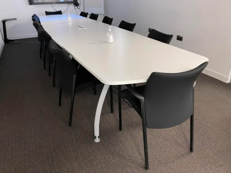 White office round meeting table with black meeting chairs